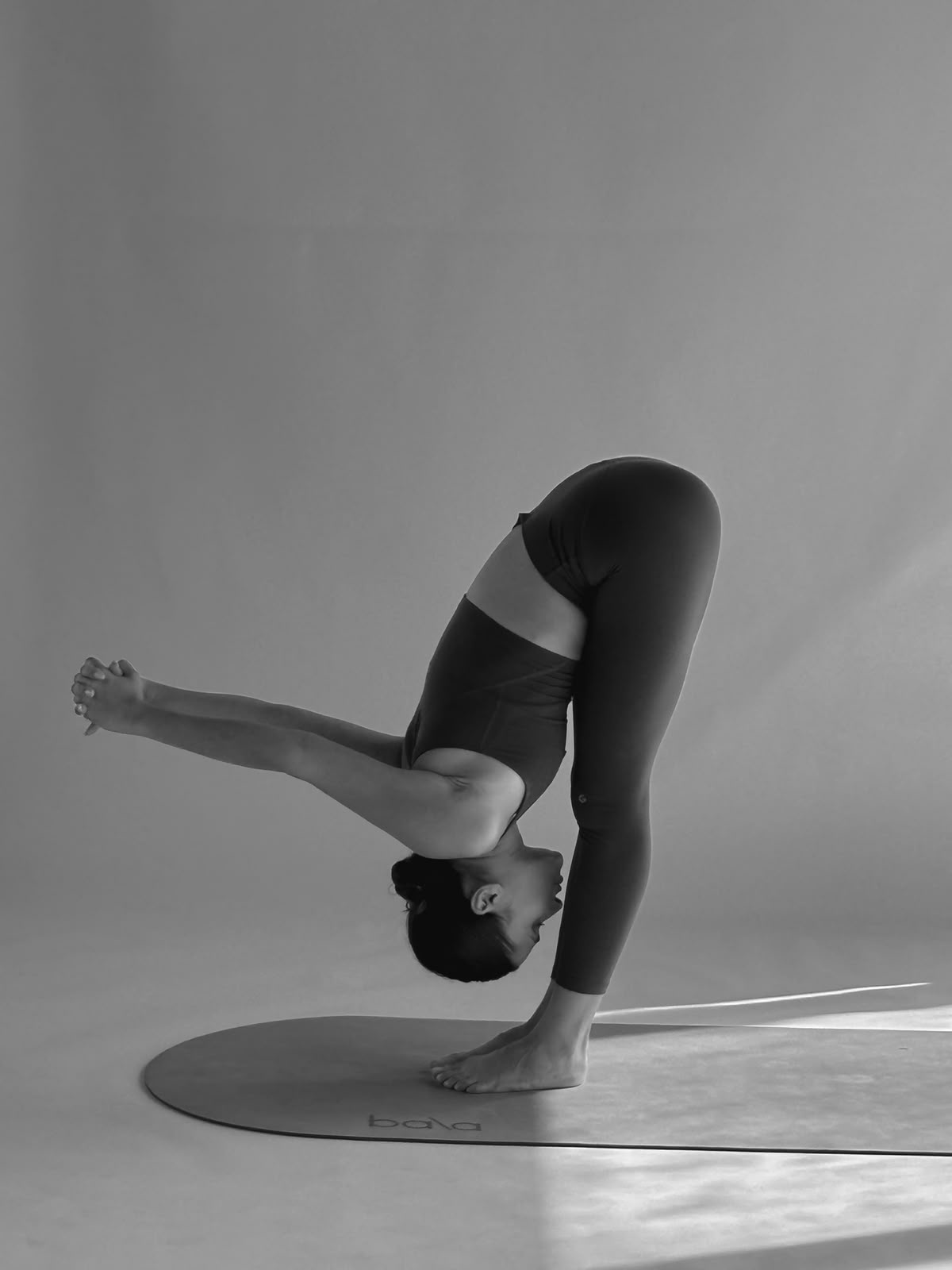 Carolina demonstrating a standing yoga fold during a TELOA session